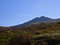先日撮影で知り合った方に山の写真を見せていただいて、そのケタ違いのレベルに圧倒されました。
登山する体力もない私が冬山や、早朝の山の写真なんて撮れるハズがありません。
でも刺激をもらったので早速天気のいい日に鳥海山へ(笑)
丁度、飛行機が山頂をかすめるように通過していきました。 鳥海山山頂と飛行機 2010 1002